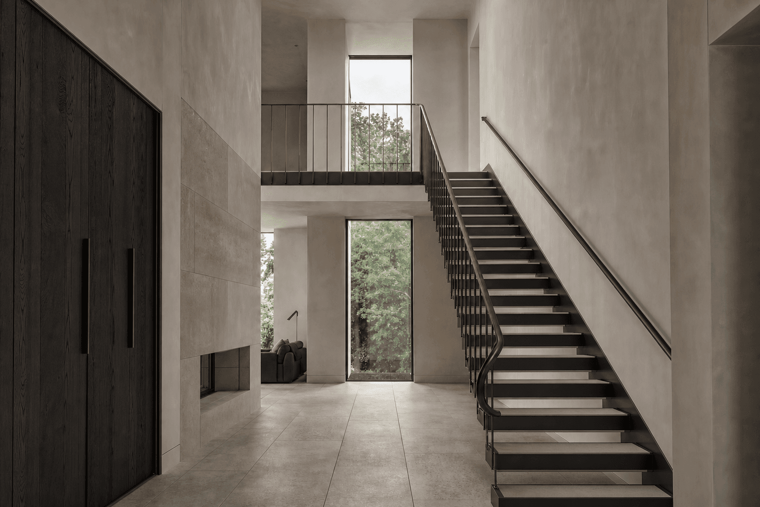 Sculptural blackened steel staircase with limestone treads and a bronze handrail