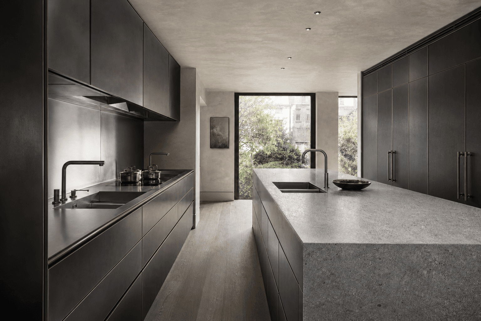 Long bespoke blackened metal work surface with integrated architectural detailing