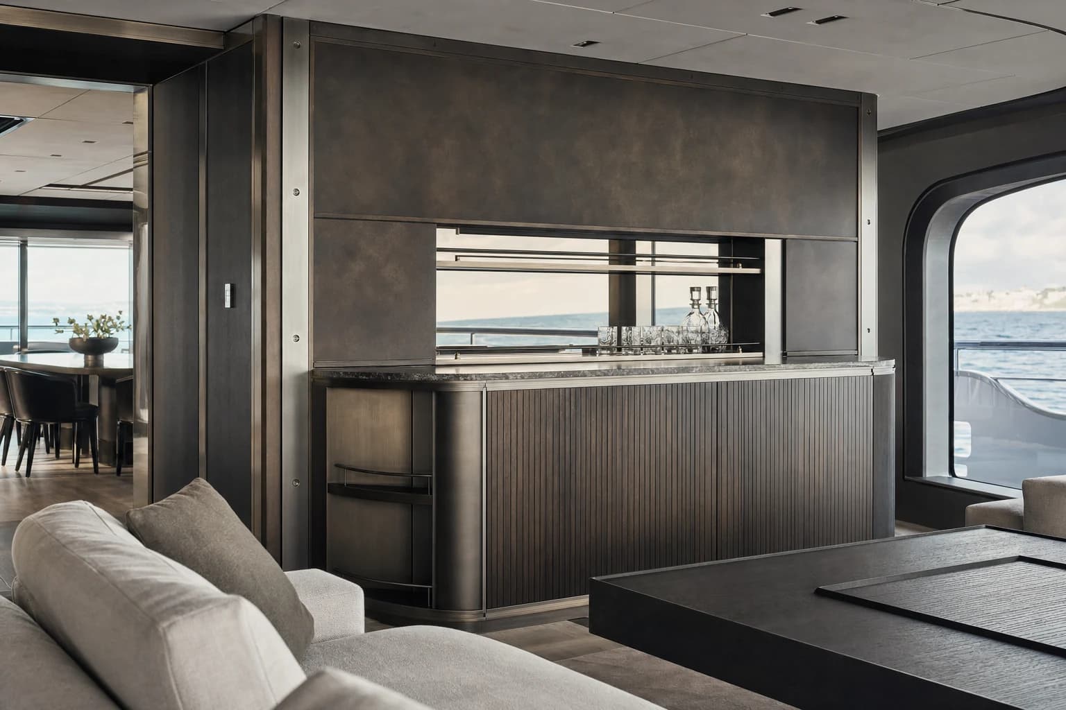Bespoke superyacht interior with patinated metalwork and dark timber cabinetry