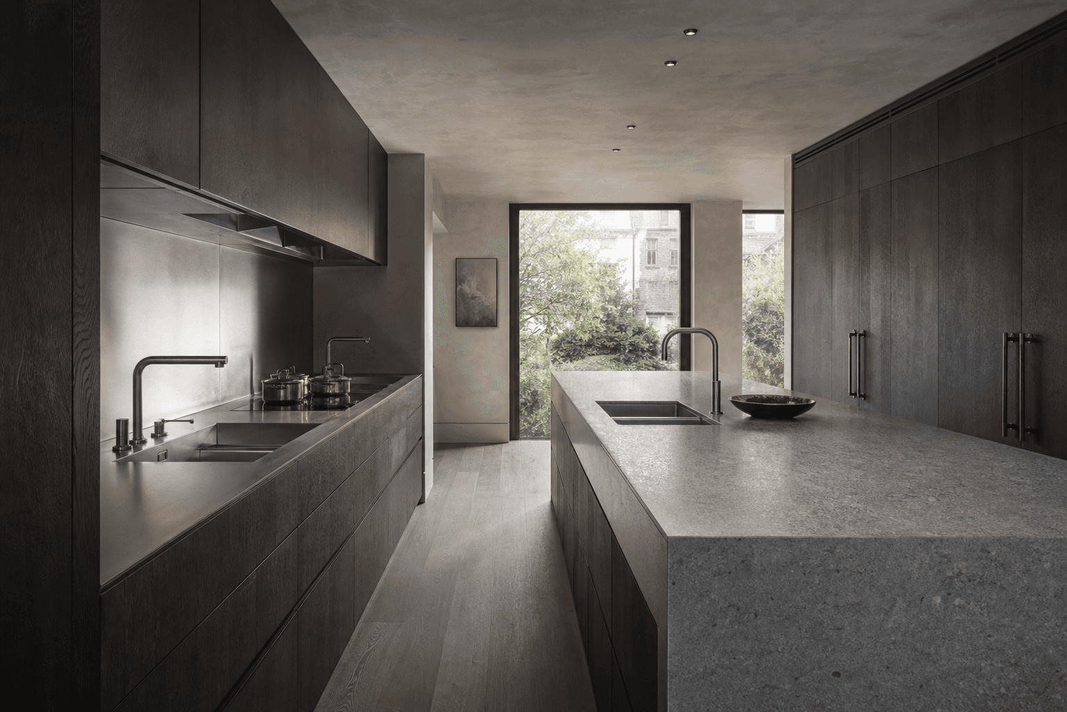 Bespoke dark oak and stone kitchen overlooking a garden